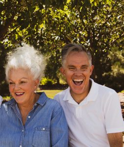 Lady with white hair and grey haired man laughing
